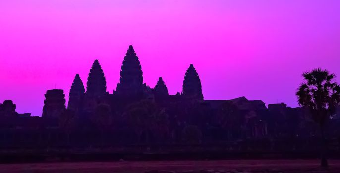Panorama Mist sunrise tropical morning violet mauve sky landscape tourist attraction temple facade silhouette of the UNESCO Angkor Wat temple in Angkor Archaeological Park Siem Reap Cambodia.