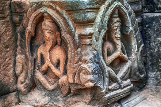 Bas-reliefs are individual figures jungles of ruins Angkor Khmer architecture Detailed carvings on the pink limestone walls of Banteay Srei temple near Angkor wat Siem Reap Cambodia