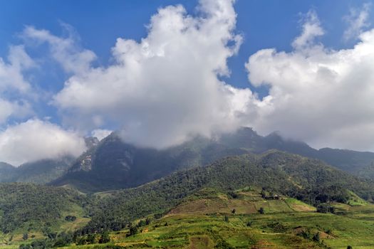 Green mountain range sky scene white clouds panorama.