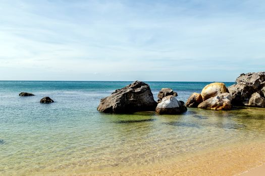 Ocean coast with rock beach with soft waves background seashells on sea sand summer sea