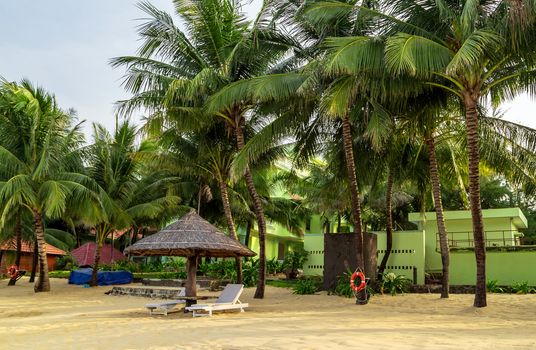 Tropical views from Long Beach Phu Quoc Island, Vietnam. Nobody on the beach. Palm tree bamboo umbrellas and sun chairs in background.