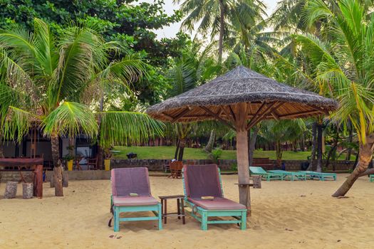 View of resort beach with golden sand, umbrellas and chairs. Summer landscape. Beautiful tropical place in Vietnam. Vacation holidays summer background.
