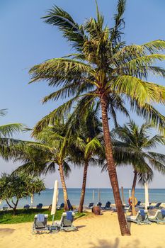 Tropical views from Long Beach Phu Quoc Island, Vietnam. Nobody on the beach. Palm tree bamboo umbrellas and sun chairs in background.