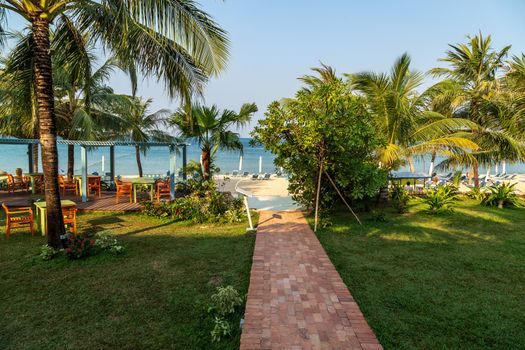 Path to the beach under green palm leaves. Upscale natural decor for landed property such as bungalow houses, villas and mansions terraces. Summer background. Phu Quoc island in Vietnam.