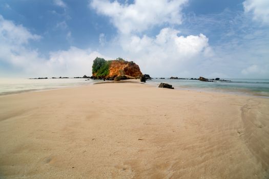 sandy tropical beach, front of the viewpoint on orange rock where you can see both sides of Mirissa bay, Sri lanka