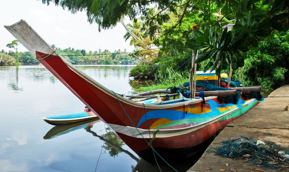 Sri Lankan traditional fishing catamarans, Colorful fishing boats on a long sandy beach on the ocean coast of Sri Lanka. Popular landmark fishing Ceylon village.