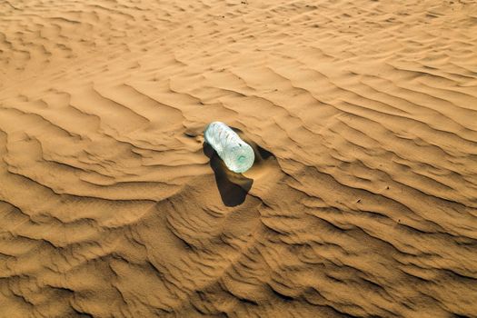 water bottles in sand dunes eco concept nature landscape desert