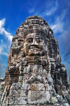 Buddhist Stone face Khmer Smile in Bayon Temple Angkor Thom, Cambodia. Ancient monument Khmer architecture.