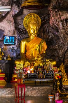 Stone statue of Buddha sitting in lotus pose gold-plated.