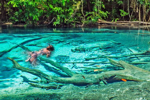 young girl diver snorkeling on a sunny day Emerald blue Pool. Blue Lake, Khao Pra Bang Khram wildlife sanctuary, Krabi province, Thailand