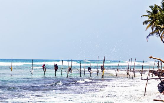 Silhouettes of the traditional fishermen, Local traditional stilt fishermen fishing rod in Indian ocean, Sri Lanka.