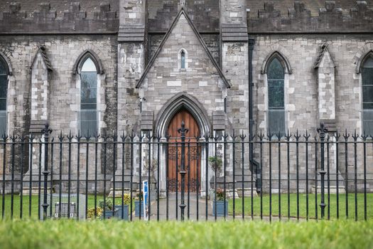 Dublin, Ireland - February 13, 2019: Street atmosphere and architecture of St Patrick's Cathedral that people visit on a winter day