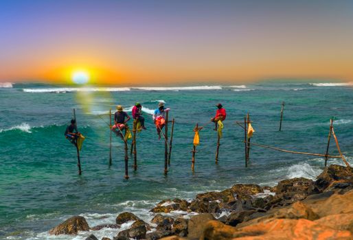 fishermen fishing rod at the sunset on stilt in Indian ocean, Sri Lanka.