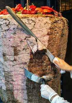 Slicing doner kebab. Grilled skewered meat served shawarma kebab sandwich Arab countries in Middle East cooking kebab shop Turkish cuisine moving to cut soft focus background