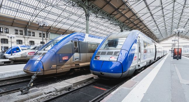 Tours, France - February 8, 2020: train at platform where people walk inside Tours train station in the city center on a winter day