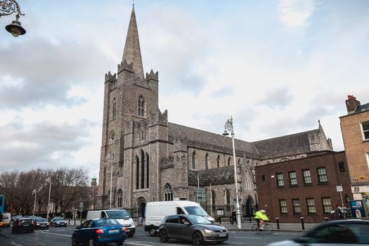 Dublin, Ireland - February 13, 2019: Street atmosphere and architecture of St Patrick's Cathedral that people visit on a winter day
