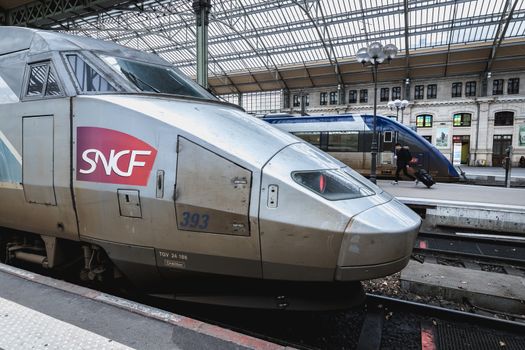 Tours, France - February 8, 2020: train at platform where people walk inside Tours train station in the city center on a winter day