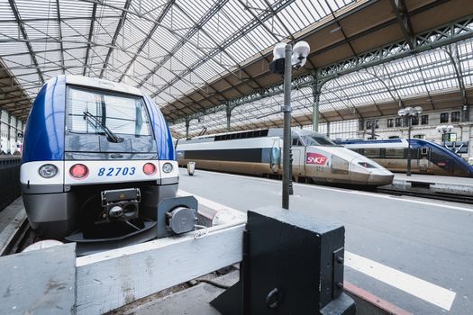 Tours, France - February 8, 2020: train at platform where people walk inside Tours train station in the city center on a winter day