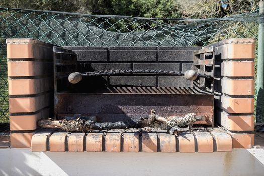 Charcoal barbecue in red brick in a garden in Portugal