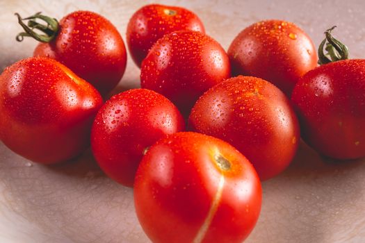 Organic ripe tomatoes in old white plate in studio