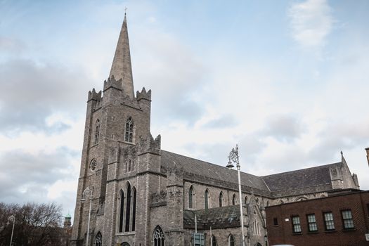 Dublin, Ireland - February 13, 2019: Street atmosphere and architecture of St Patrick's Cathedral that people visit on a winter day