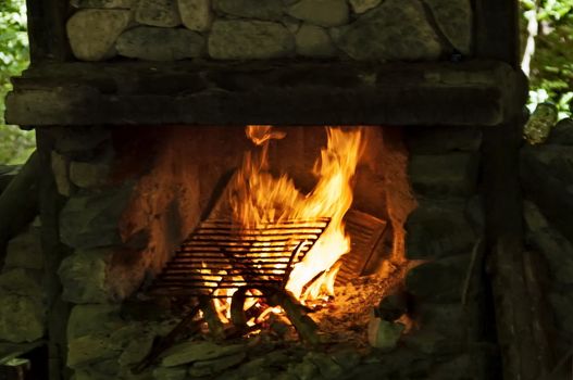 Part of stone stove   for BBQ grill with glowing coals and bright flames, Teteven Balkan, near Teteven town, Bulgaria