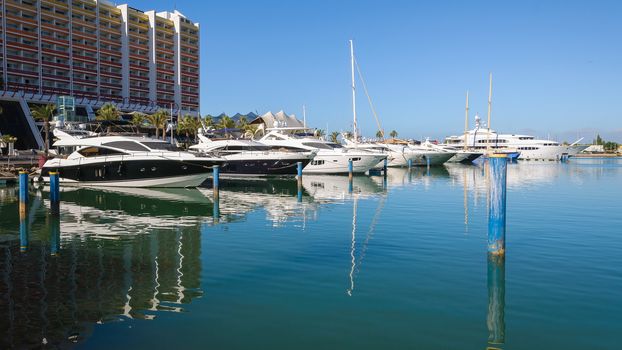 Luxury yachts moored in the port of Vilamoura at the hotel building, Algarve, Portugal