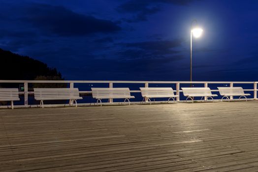 Night view of the benches on the pier in Gdynia Orlowo in Poland