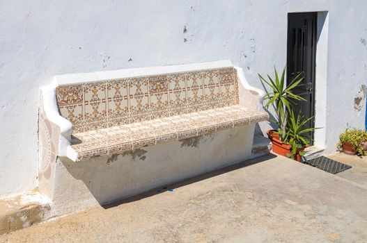 Bench decorated with traditional portuguese tiles called azulejos ath the house entrance
