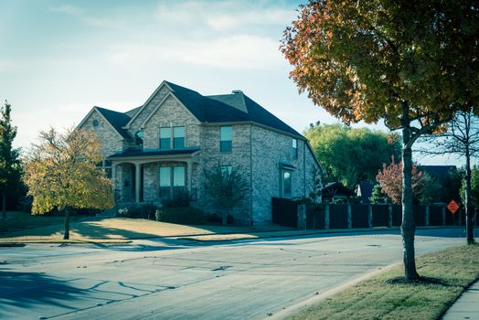 New development neighborhood with row of two story houses clean concrete sidewalk with colorful fall foliage outside Dallas, Texas, America
