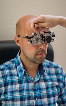 examination of the eyes of the man, with the help of special glasses in the laboratory, measurement of diopters.