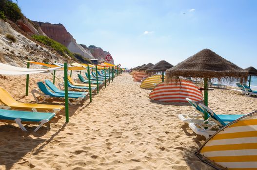 Sunbeds and umbrellas on Falesia Beach, Algarve, Portugal