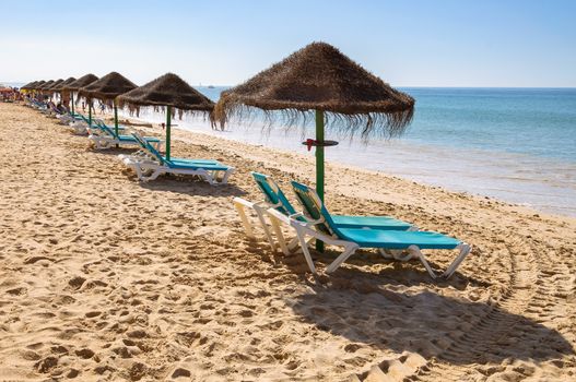 Sunbeds and umbrellas on Falesia Beach, Algarve, Portugal