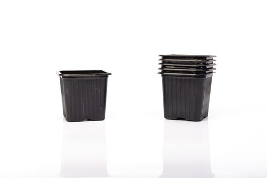 used black plastic gardening bucket waiting for spring on white background in studio