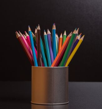 Wooden colorful pencils, on a dark background