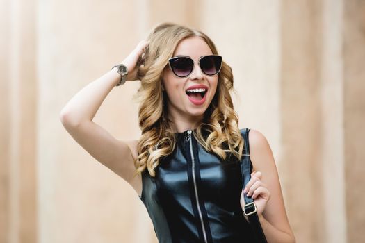 portrait of glamorous woman with glasses dressed in a black stylish dress after shopping. shopping time concept