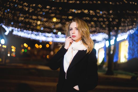 portrait of Beautiful young woman in black on a background of a night city. night life
