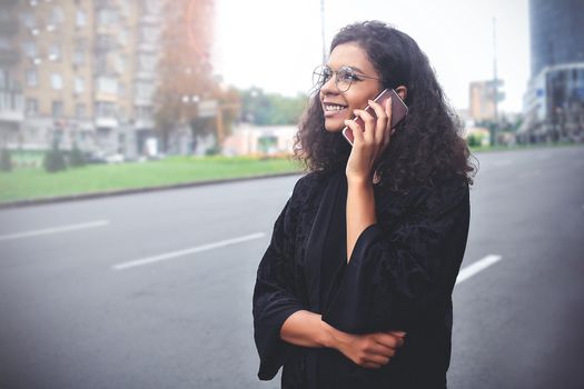 Positive emotions. Lifestyle concept. Close up of young mixed race woman use a phone.