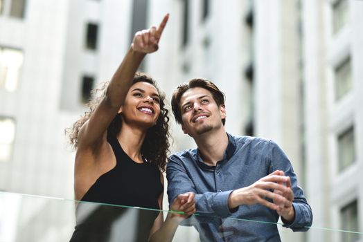 Happy international couple have a conversation in city. Mixed race woman and caucasian man.