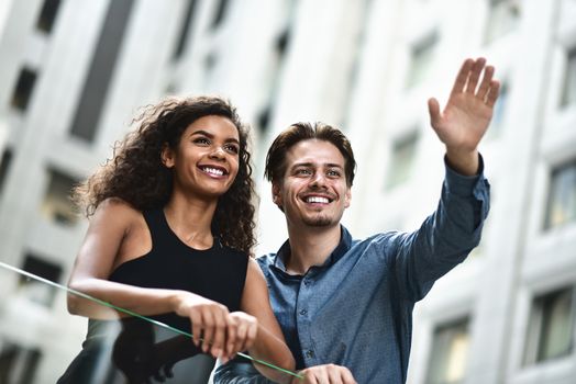 Happy international couple have a conversation in city. Mixed race woman and caucasian man.