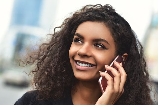 Happy beautiful woman walking and writing or reading sms messages