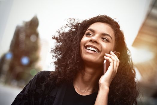 Happy beautiful woman walking and writing or reading sms messages