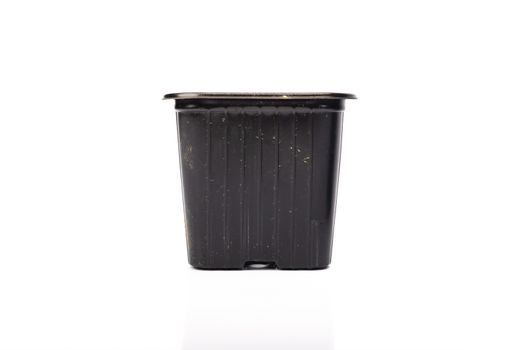 used black plastic gardening bucket waiting for spring on white background in studio