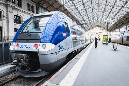 Tours, France - February 8, 2020: train at platform where people walk inside Tours train station in the city center on a winter day