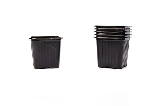 used black plastic gardening bucket waiting for spring on white background in studio