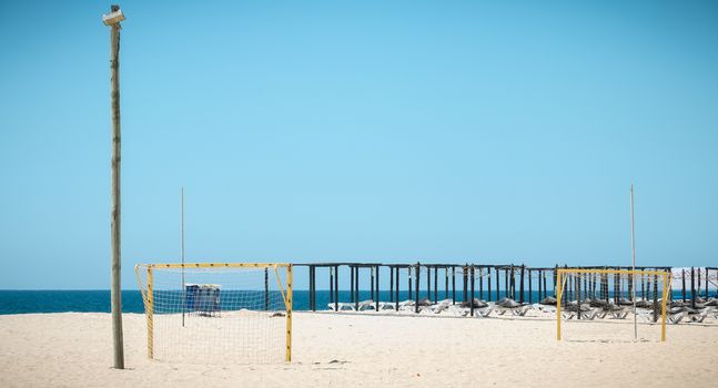 Tavira Island, Portugal - May 3, 2018: View of deckchairs and umbrellas stored on the fine sandy beach sand on a spring day