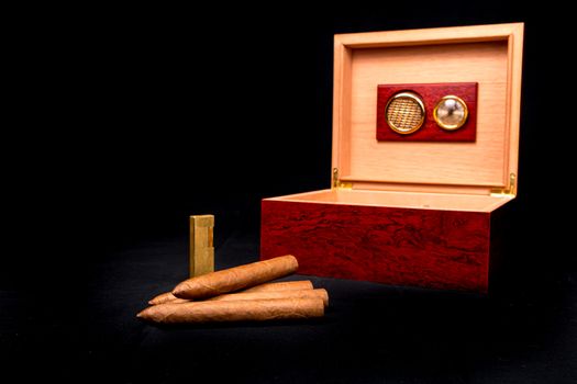 Cigar box on black background and gold lighter