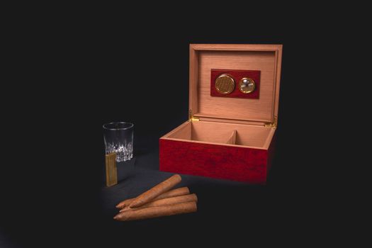 Cigar box on black background and gold lighter