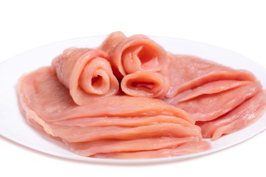 Raw sliced chicken meat close-up on a white plate and on a white background. Satilisimo. Culinary. Top view.Delicious dietary meat.