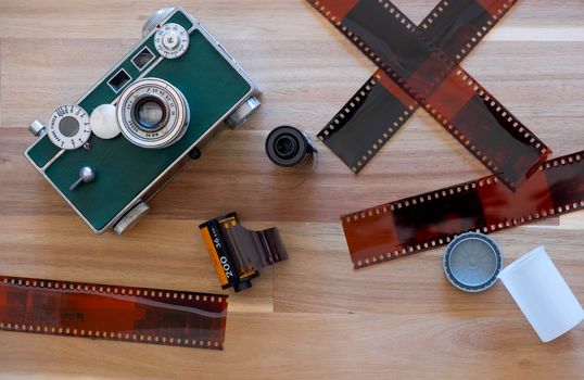 The American Film Camera Argus c3 with Kodak film and film sheet on Wooden Background